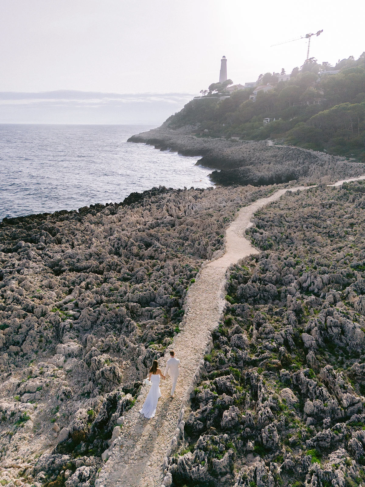 Wedding couple walking along Mediterranean rocks near Grand-Hôtel du Cap-Ferrat