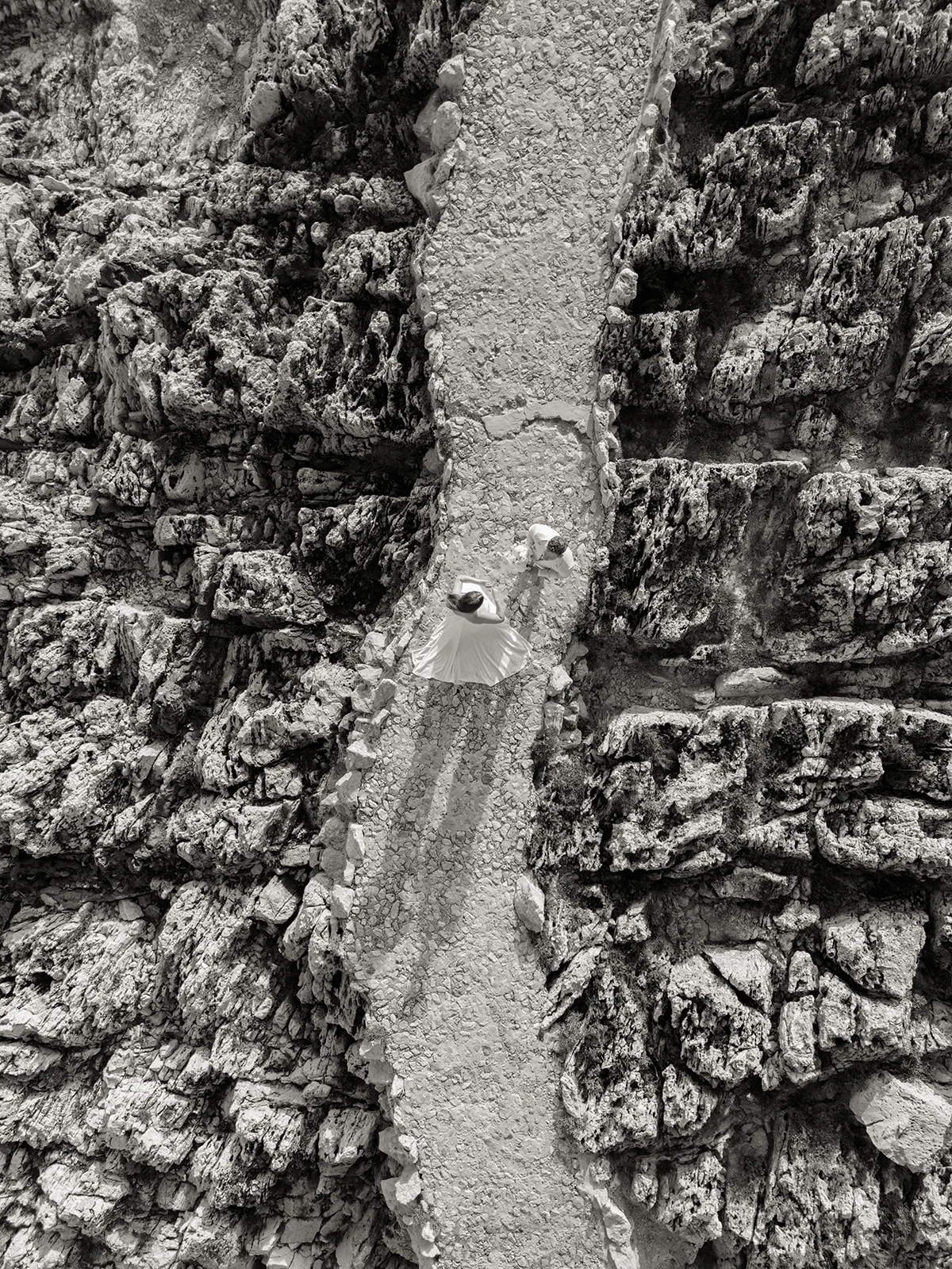 Black-and-white aerial wedding portrait on the rocky coastline of Saint-Jean-Cap-Ferrat