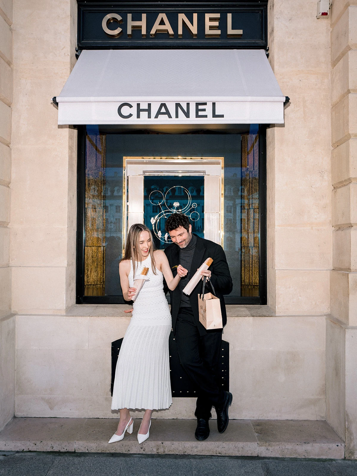 Editorial lifestyle portrait of a couple laughing outside Chanel on Rue Cambon