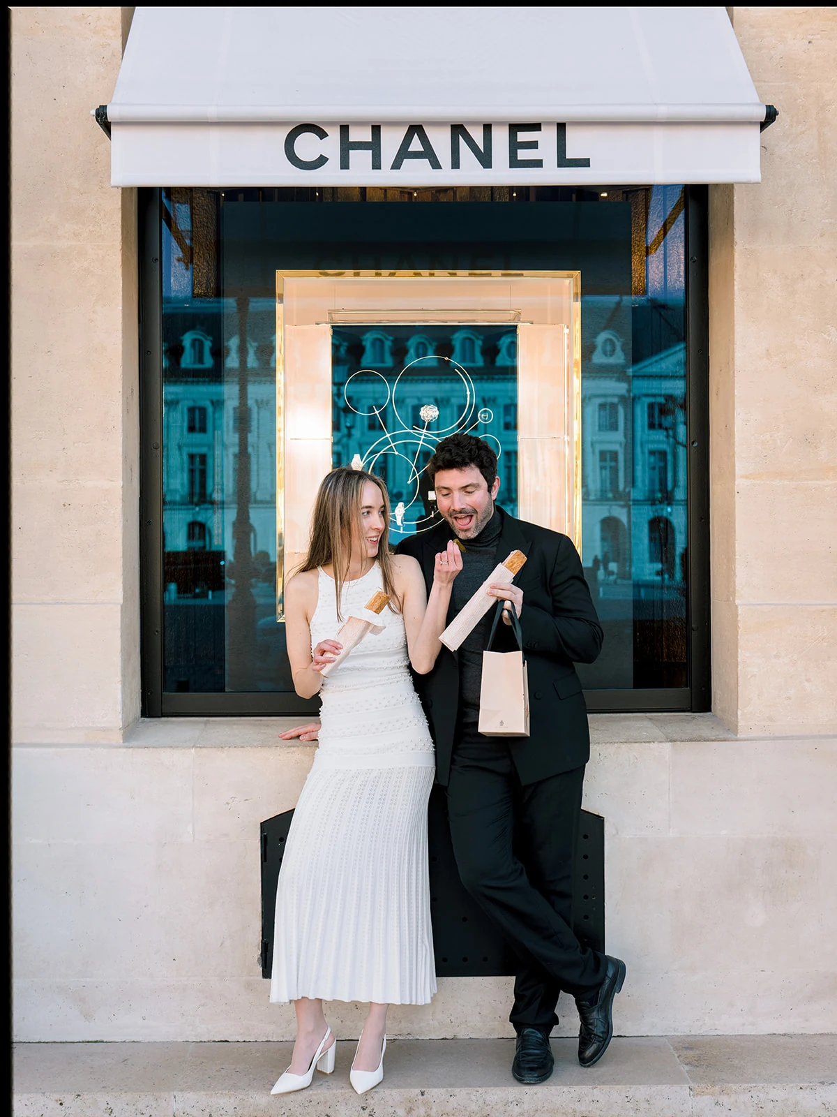 Editorial couple enjoying pastries outside Chanel on Rue Cambon in Paris