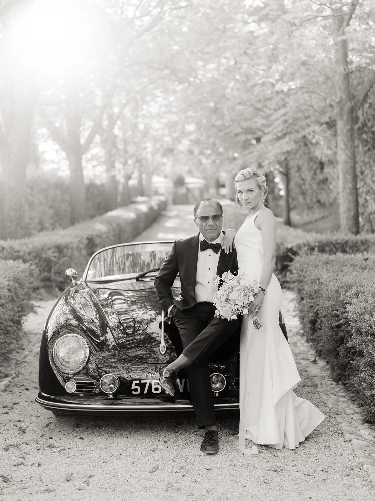Bride and groom photographed with a vintage wedding car