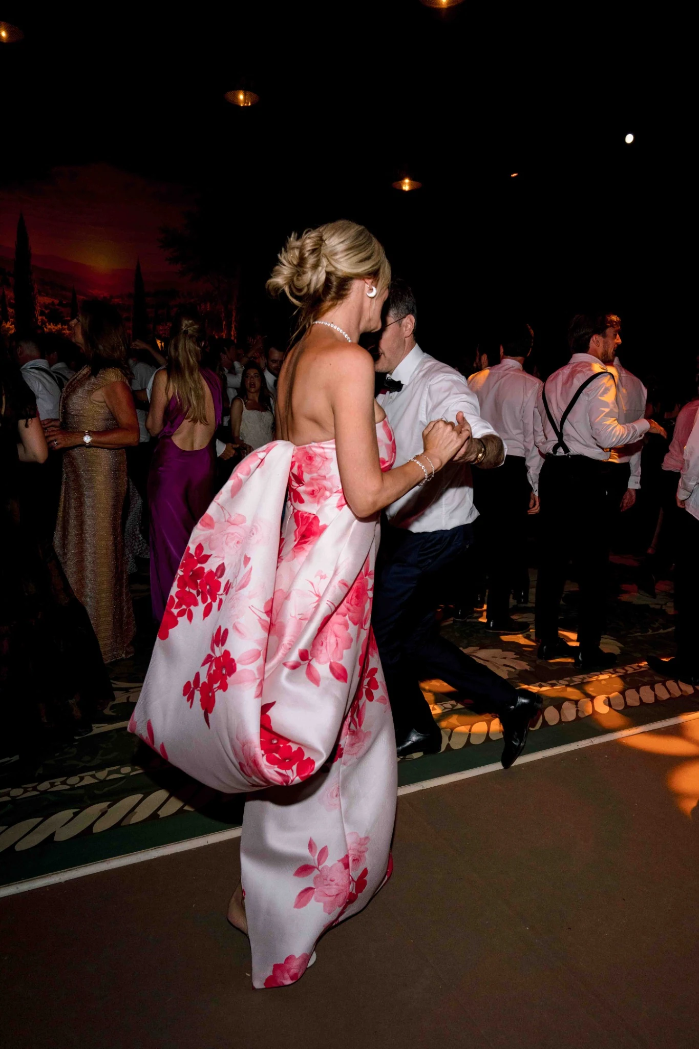 Wedding guest dancing in an elegant floral gown at Villa Baulieu