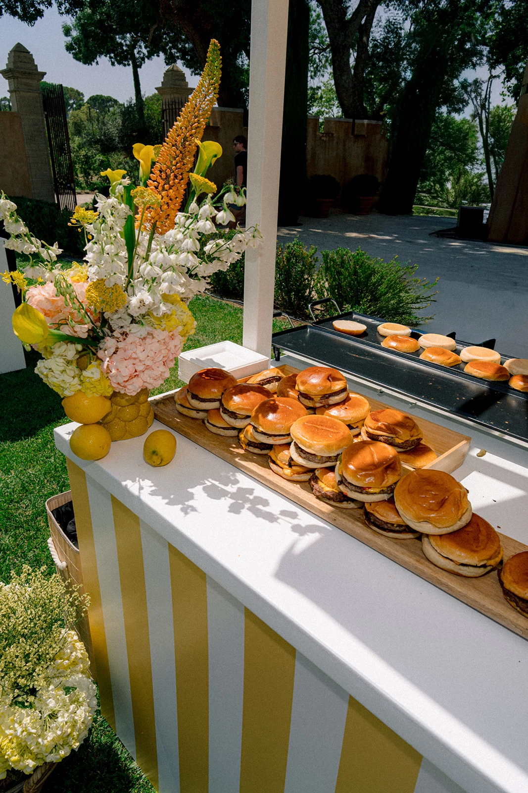 Gourmet burger station beside a post-wedding pool party