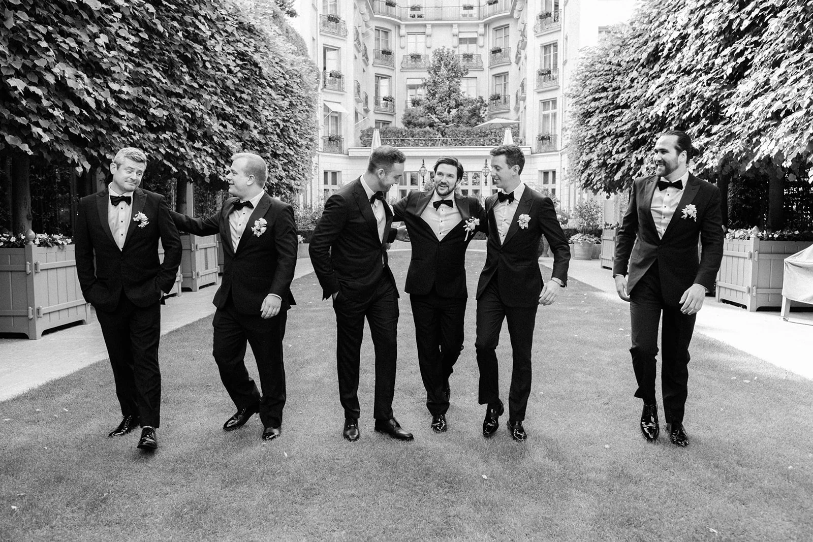 Groomsmen walking together during a luxury hotel wedding in Paris