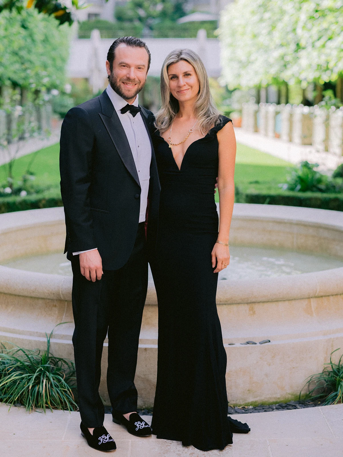 Invités en tenue de soirée photographiés près de la fontaine du Ritz Paris