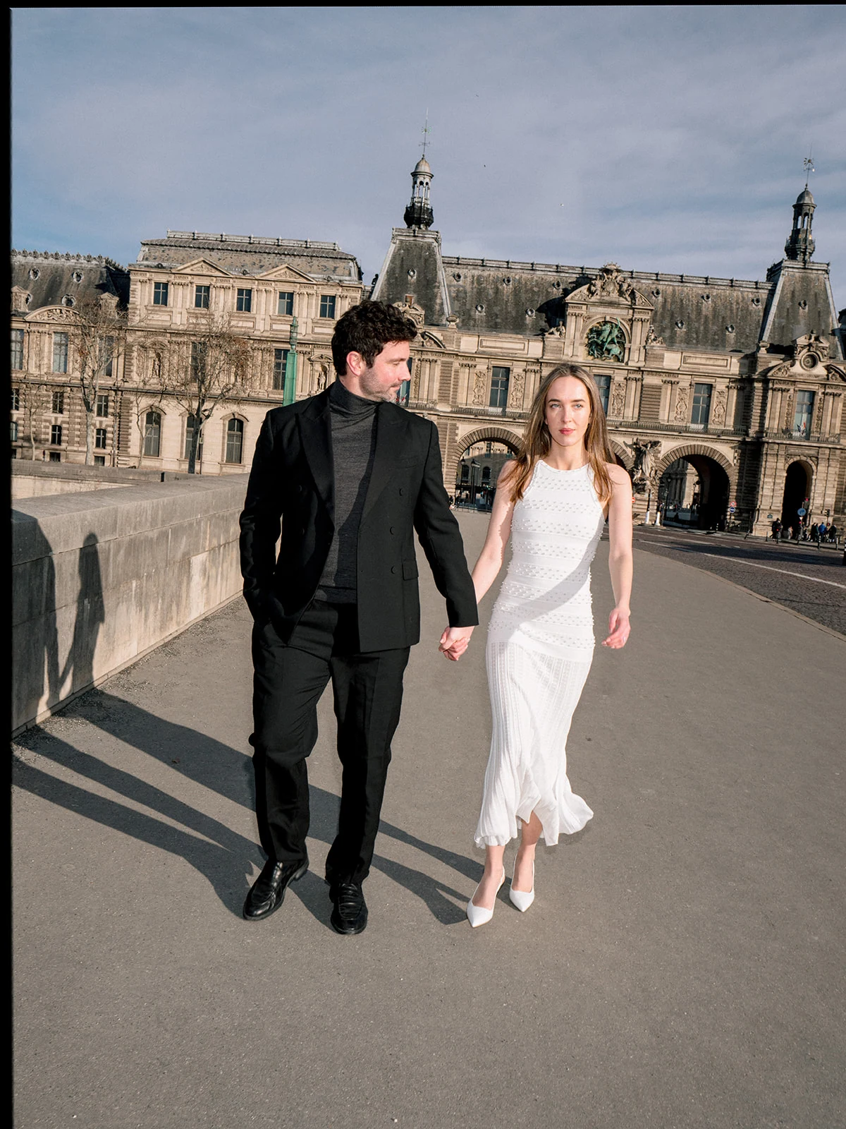 Fashion-forward couple walking at the Louvre during a modern editorial Paris session