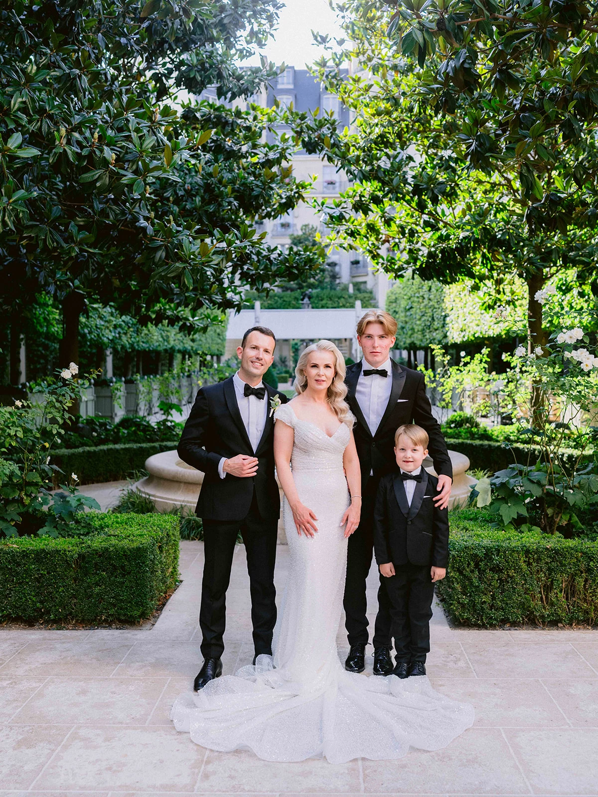 Portrait de famille en tenue de soirée dans le jardin d'un palace parisien