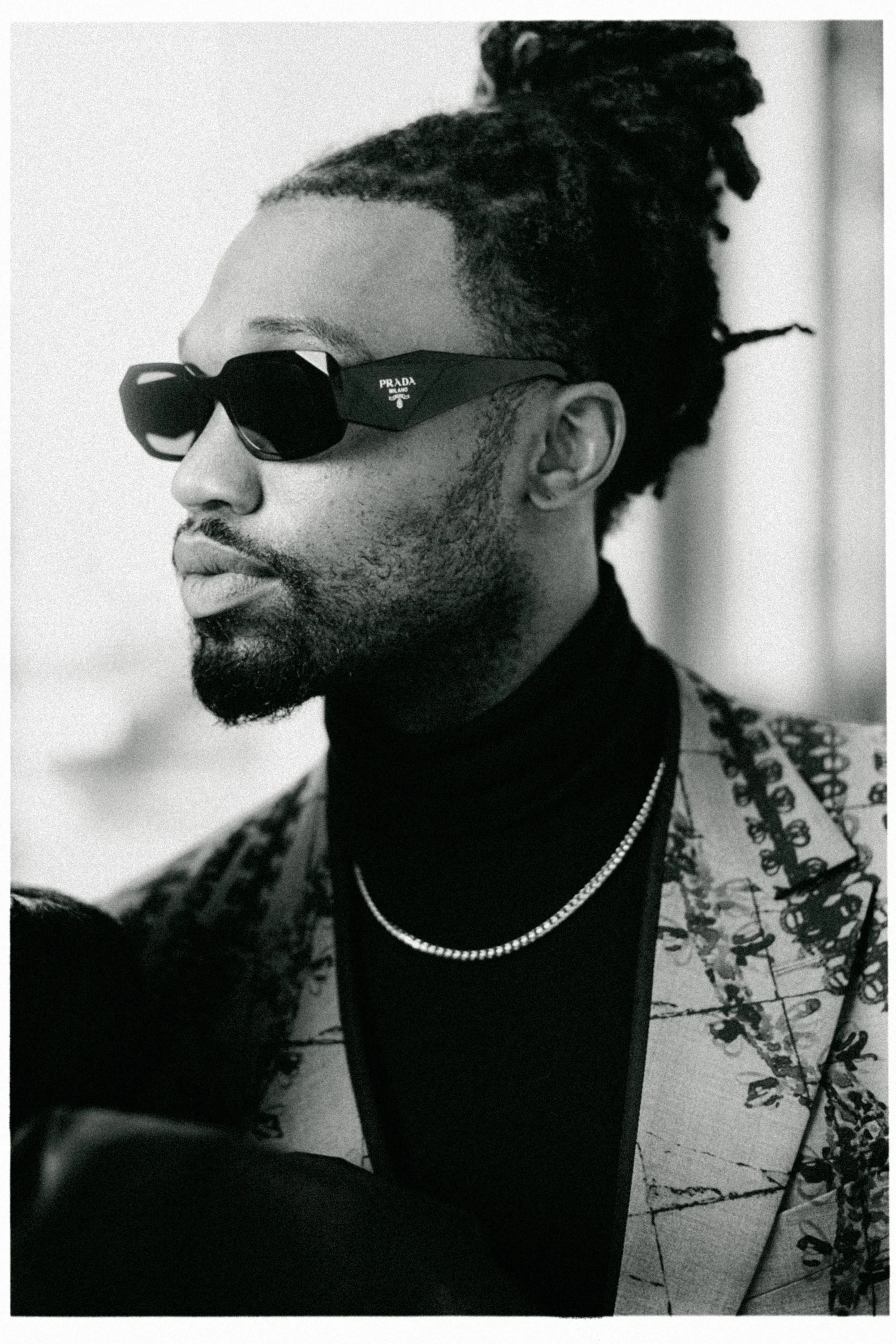 Black-and-white fashion portrait of Omar Bolden wearing sunglasses at the Louvre in Paris