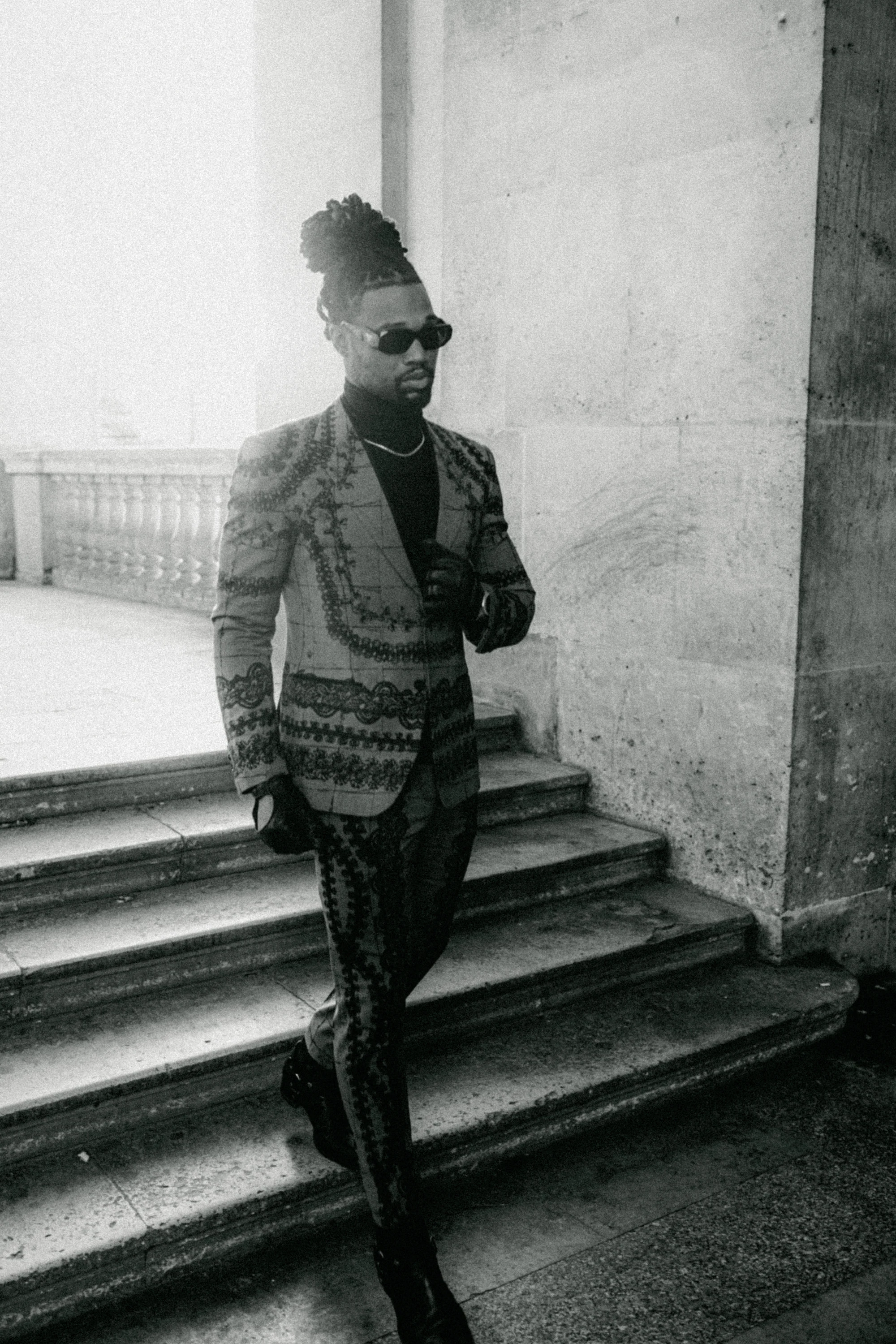 Black-and-white fashion portrait of Omar Bolden beneath the Louvre arcades in Paris