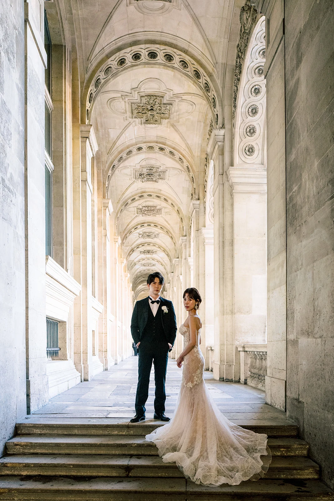 Asian couple framed by the Louvre architecture during a Paris wedding session