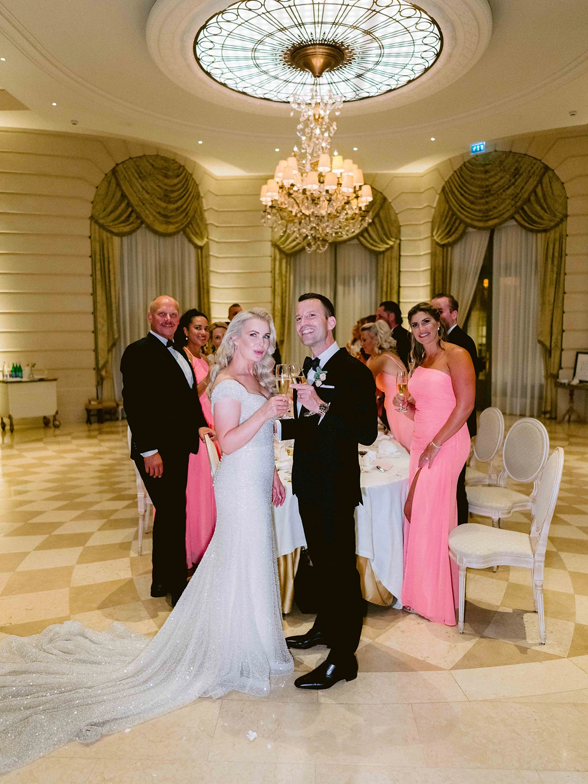 Bride and groom raising champagne during their wedding reception at The Ritz Paris