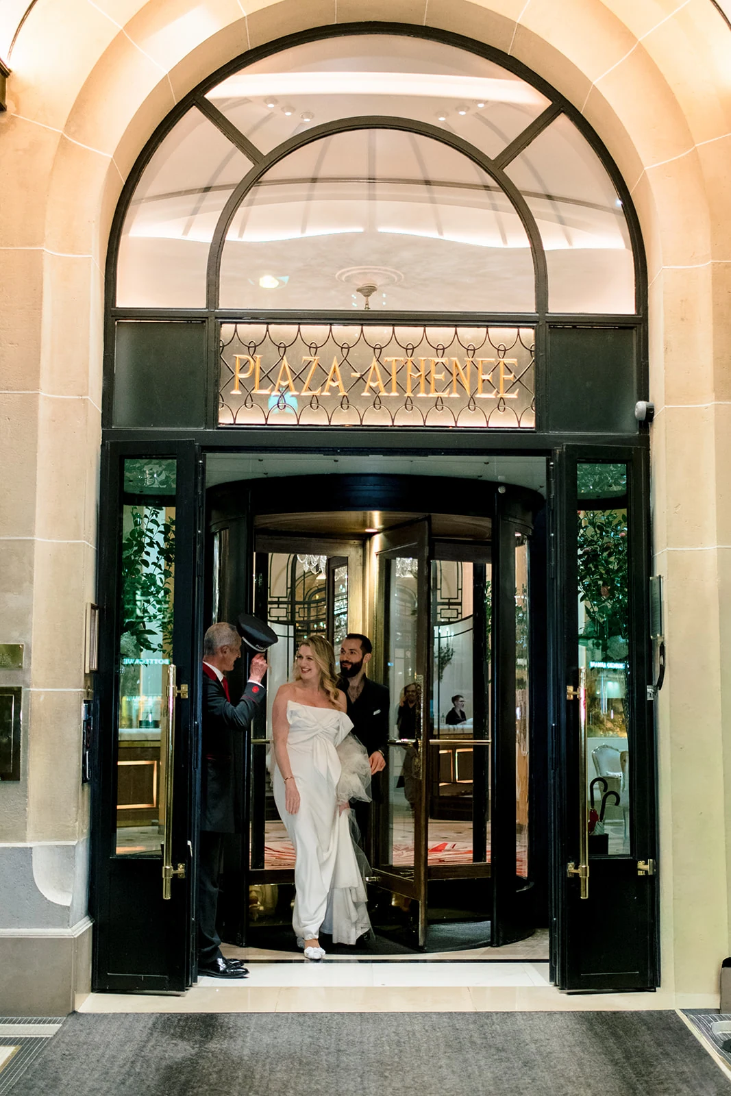 Newlyweds framed by the illuminated entrance of Hôtel Plaza Athénée Paris