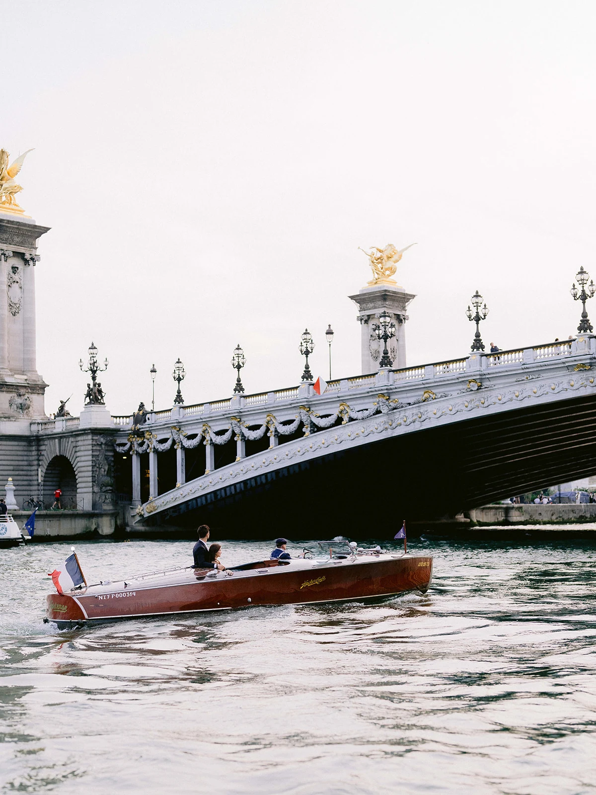 Private boat passing Pont Alexandre III during a Paris engagement photo session