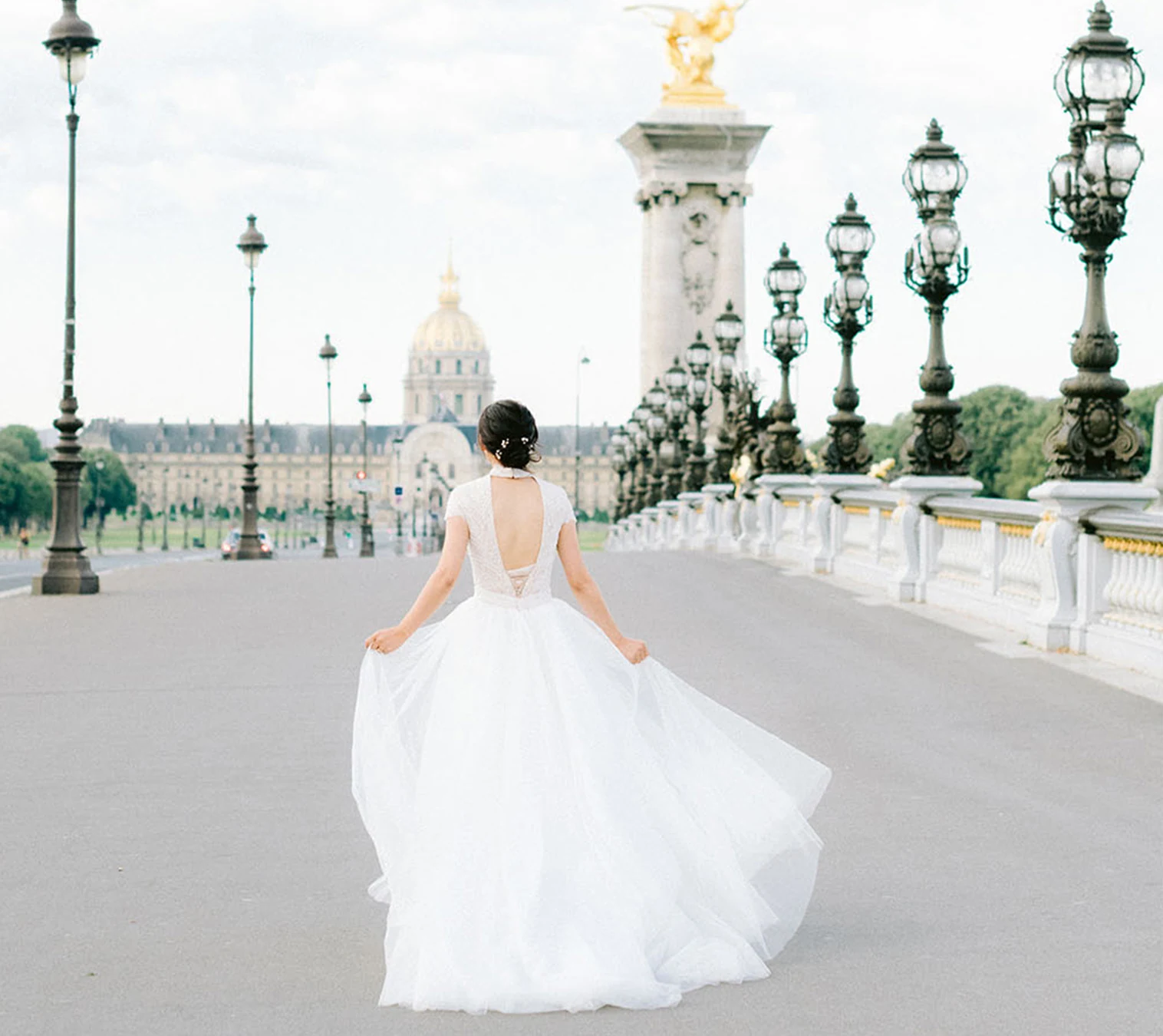 Bride running across Pont Alexandre III during a pre-wedding photo session in Paris