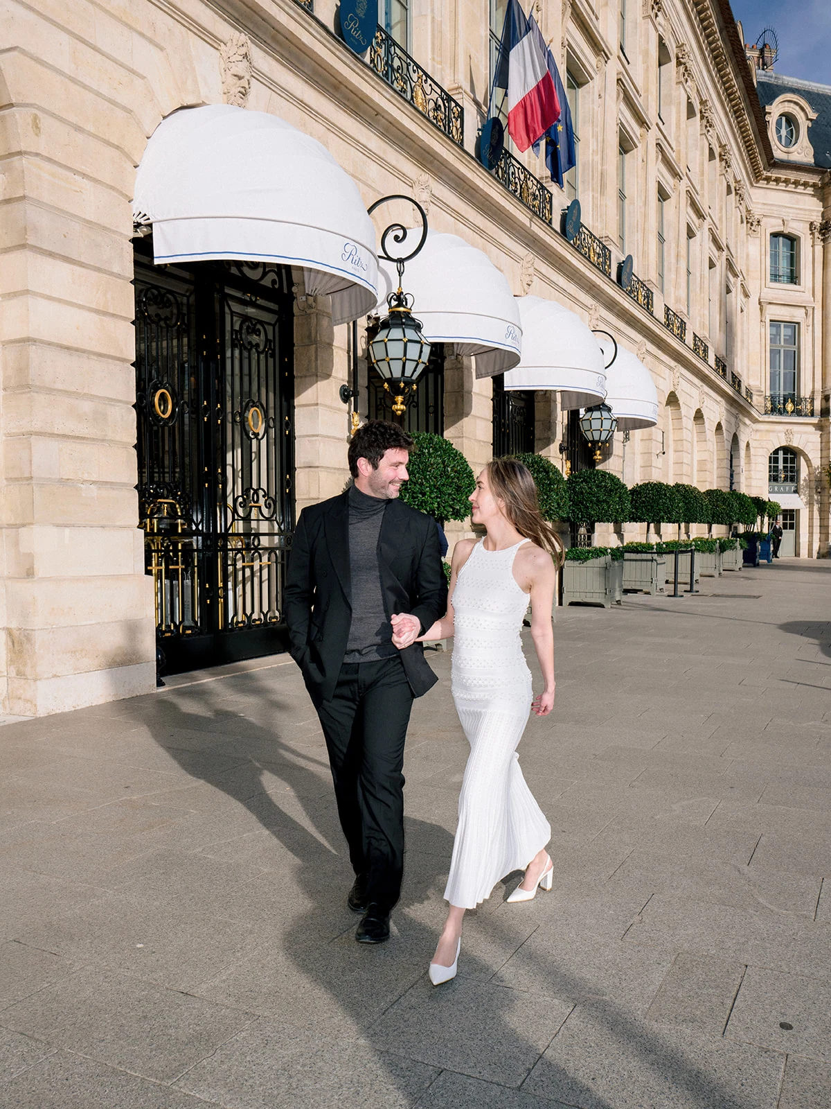 Editorial couple walking together outside the Ritz Paris on Place Vendôme