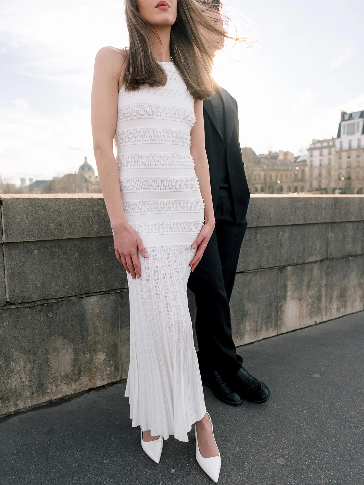 Fashion detail of a white beaded dress photographed beside the Seine in Paris