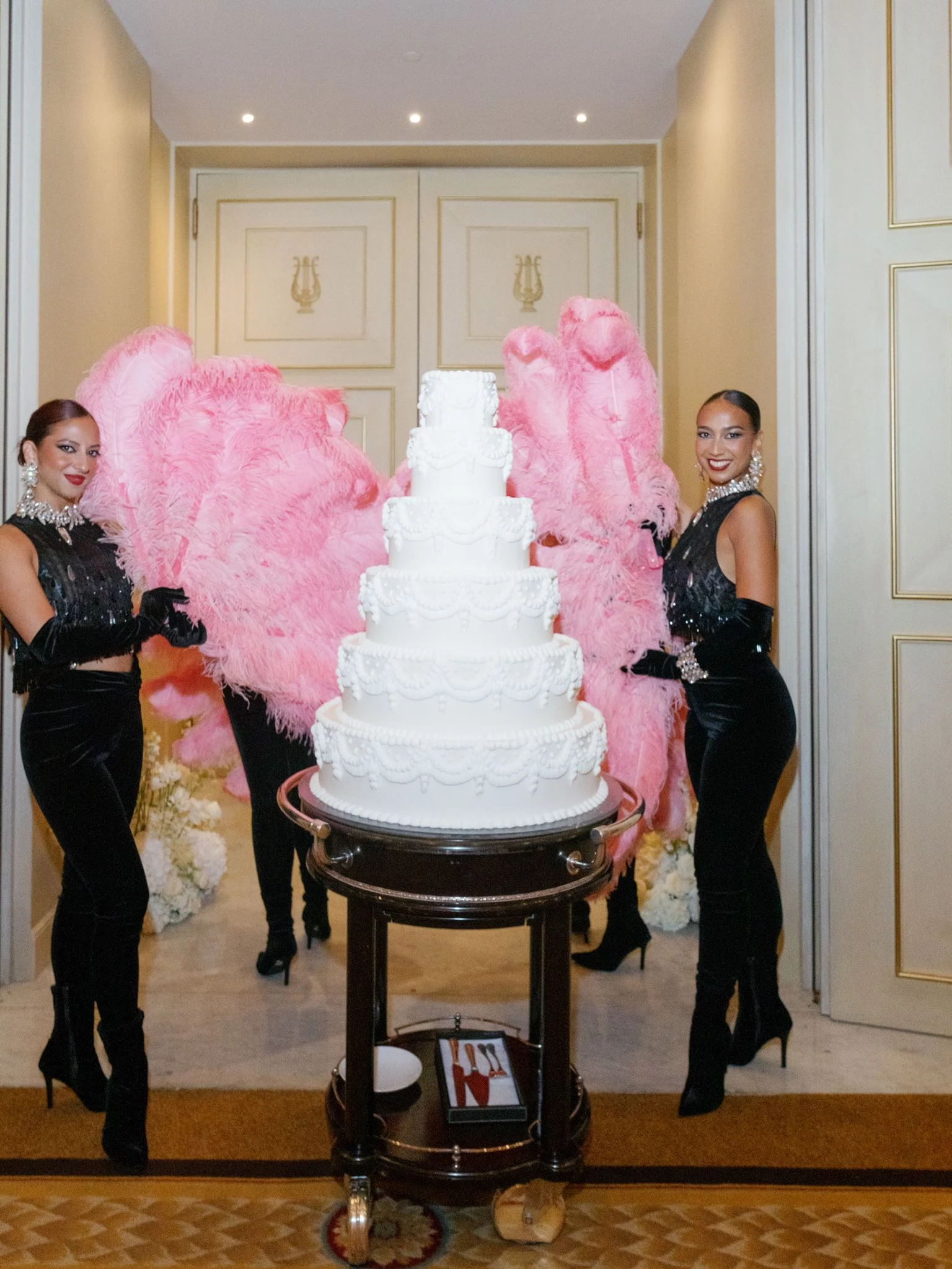 Wedding cake framed by pink feather performers at Shangri-La Paris