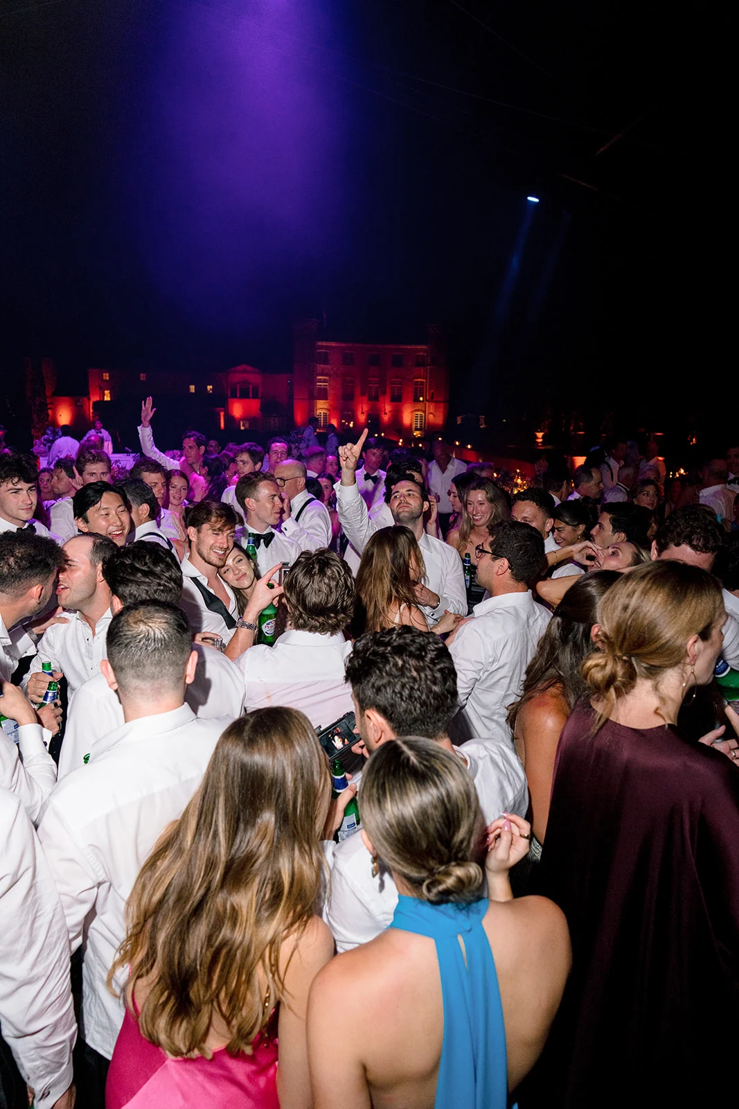 Packed wedding dance floor under stage lights at Villa Baulieu in Provence