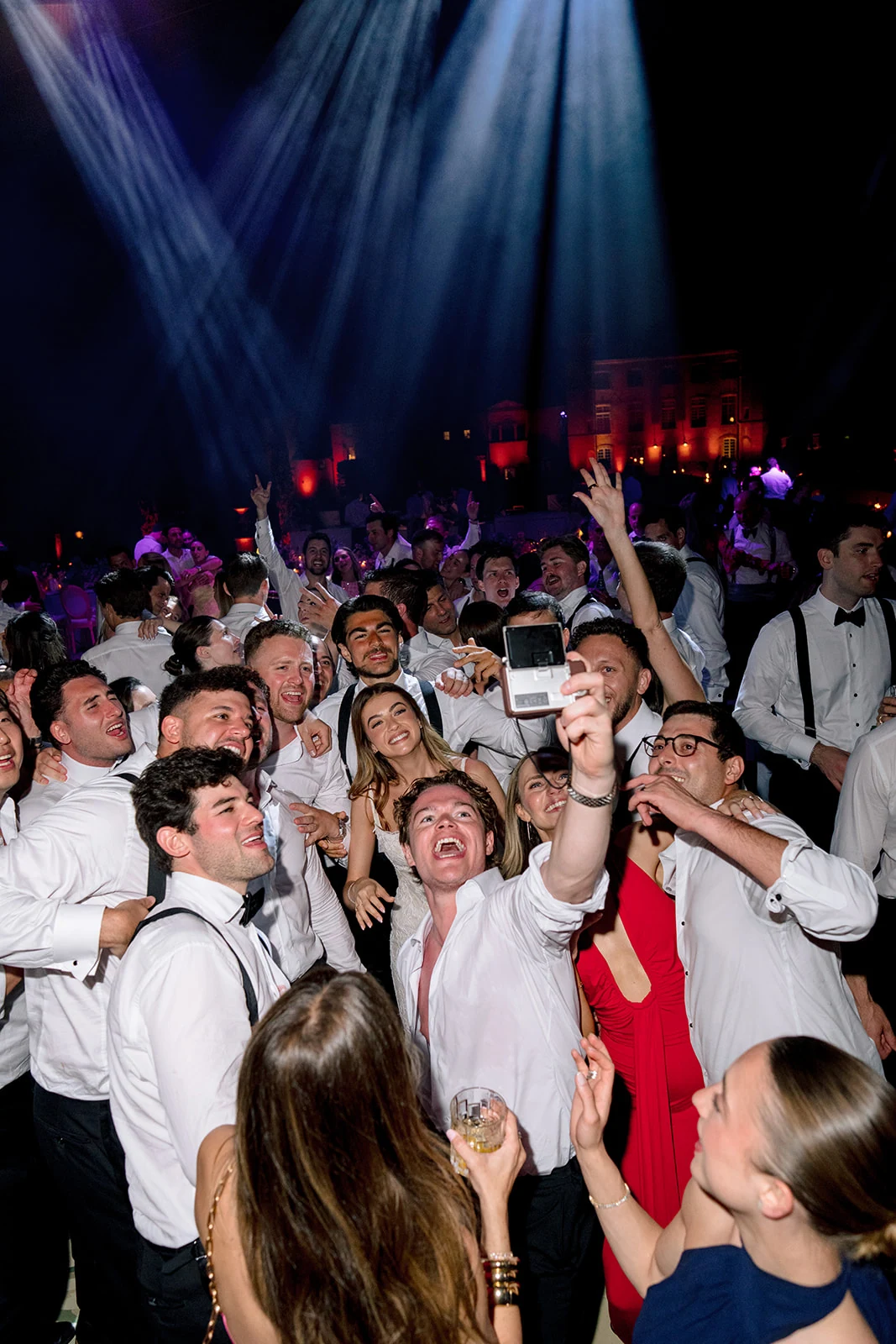 Wedding guests taking a group selfie on the dance floor at Villa Baulieu