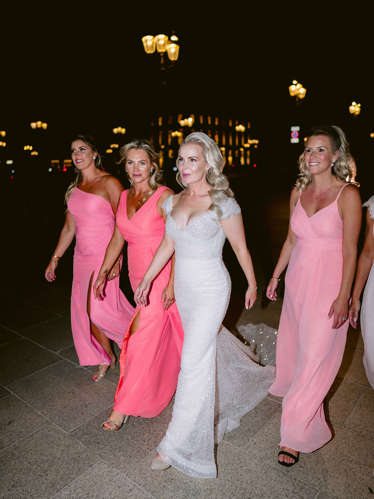 Bride walking through Paris at night with her bridesmaids after the Ritz reception